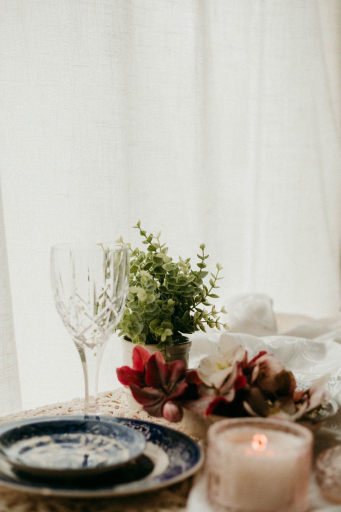 A beautifully set Sunday dinner table with heirloom China, Crystal Goblets and a beeswax candle.